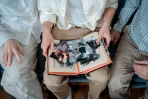 Pessoas observam fotografias antigas em um álbum de família.