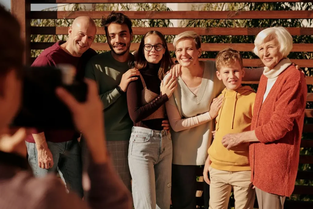 Família de diferentes gerações posa para uma fotografia ao ar livre.